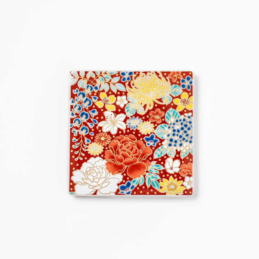 Square Japanese ceramic coaster with vivid red base featuring peony, chrysanthemum, and floral motifs in multicolor design.