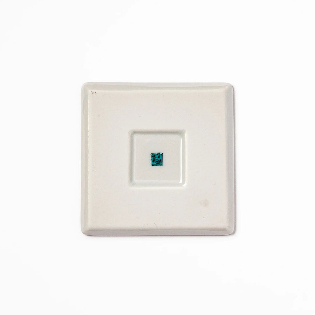 Square Japanese ceramic coaster with vivid red base featuring peony, chrysanthemum, and floral motifs in multicolor design.