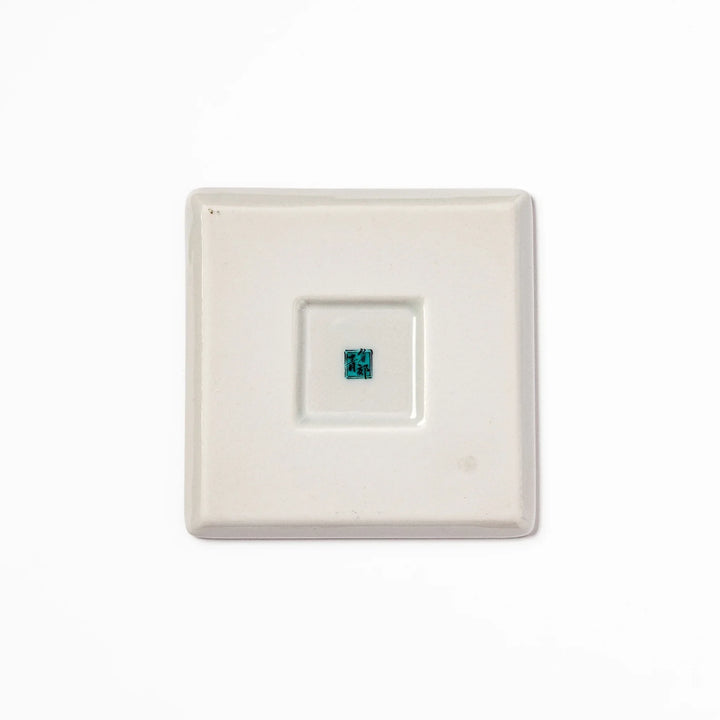 Square Japanese ceramic coaster with vivid red base featuring peony, chrysanthemum, and floral motifs in multicolor design.