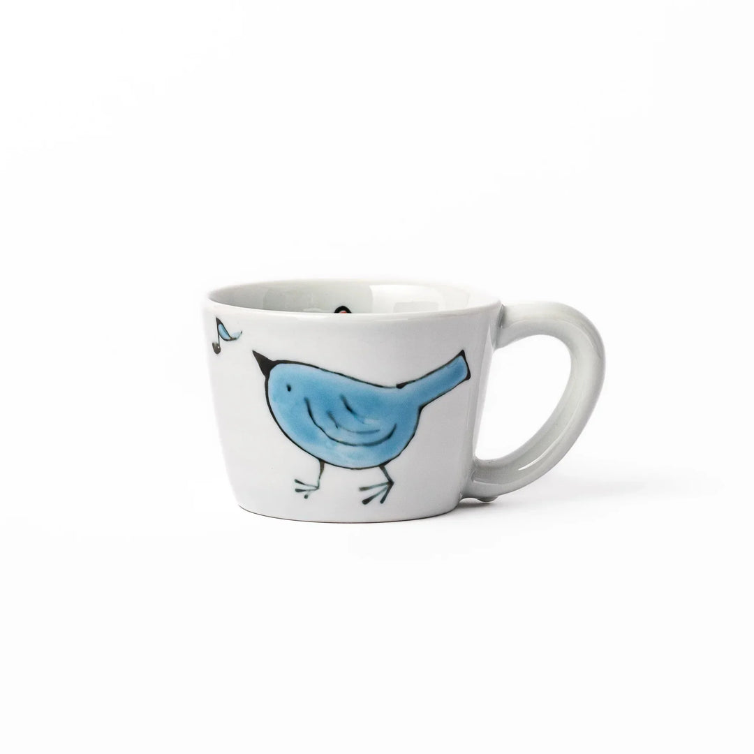 Children’s mug with hand-painted blue bird and musical notes, crafted from white porcelain for joyful sips.