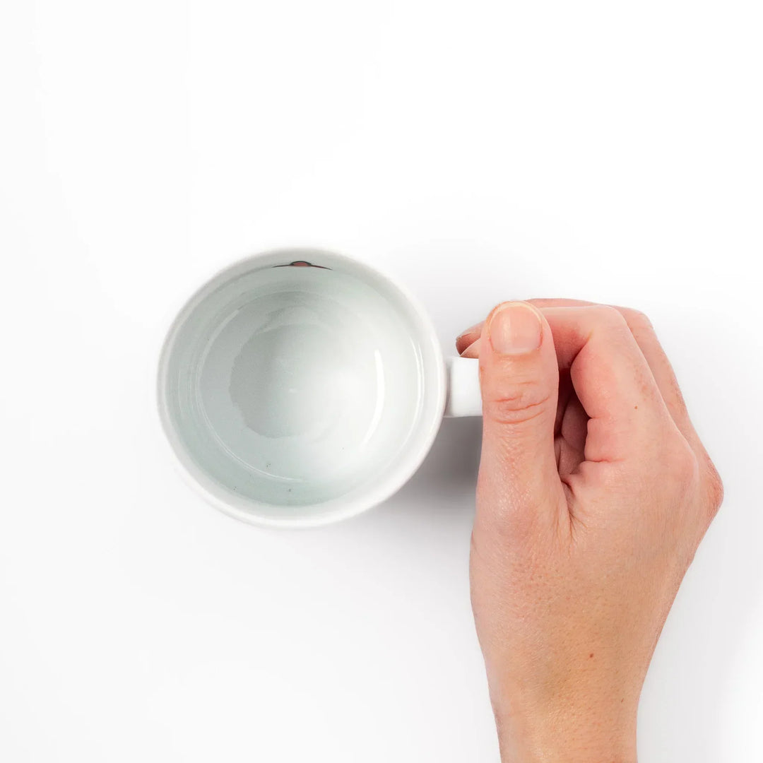 Children’s mug with hand-painted blue bird and musical notes, crafted from white porcelain for joyful sips.