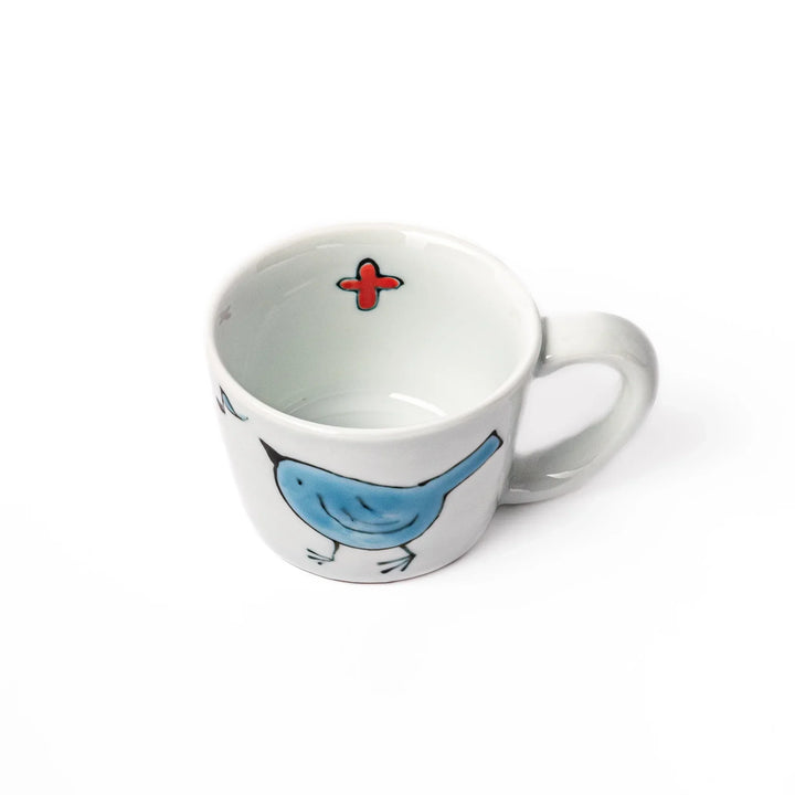 Children’s mug with hand-painted blue bird and musical notes, crafted from white porcelain for joyful sips.