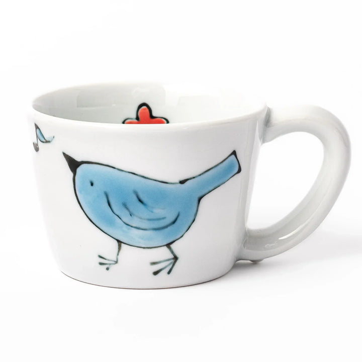 Children’s mug with hand-painted blue bird and musical notes, crafted from white porcelain for joyful sips.