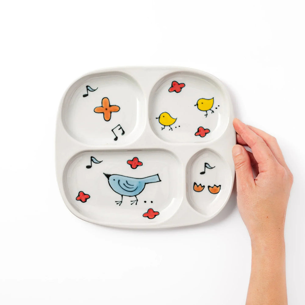 Children’s divided plate with blue and yellow birds, flowers, and notes, designed for fun, easy mealtime organization.
