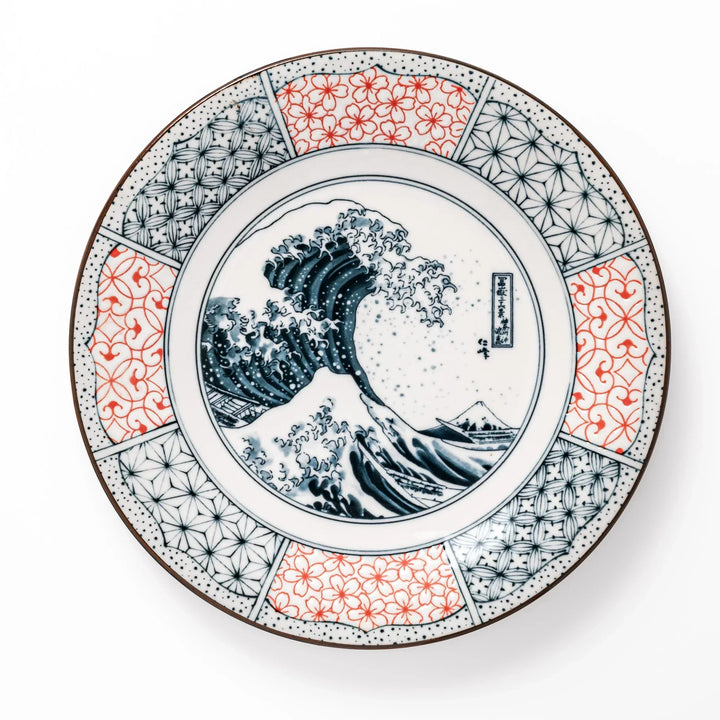 Japanese porcelain dinner plate featuring Hokusai Great Wave design with red and blue geometric border patterns.