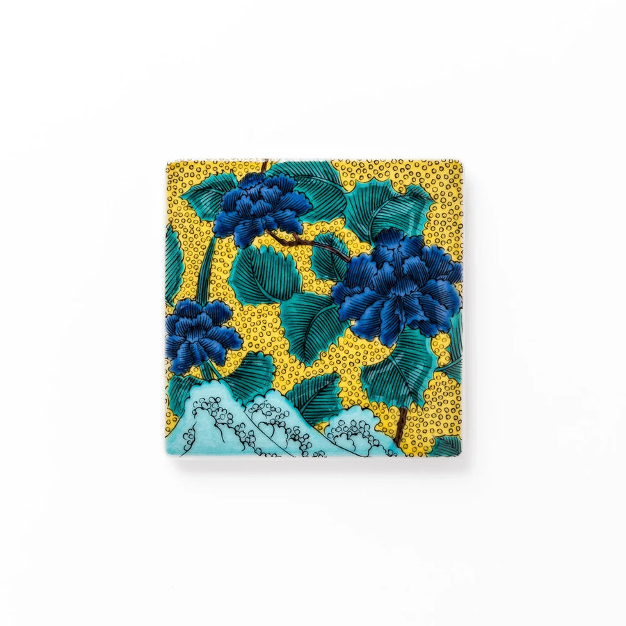 Japanese porcelain coaster with blue peony and green leaf design on yellow background, inspired by traditional Kutani ware.