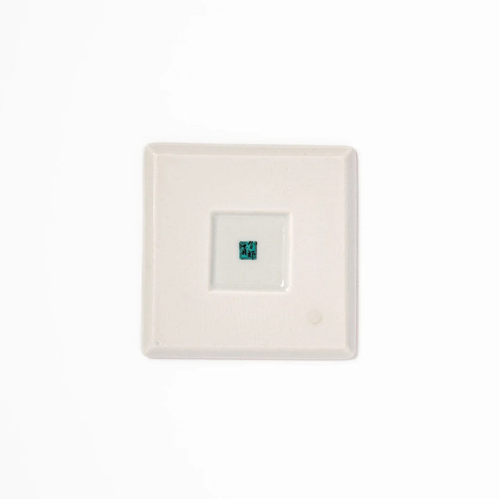 Japanese porcelain coaster with blue peony and green leaf design on yellow background, inspired by traditional Kutani ware.