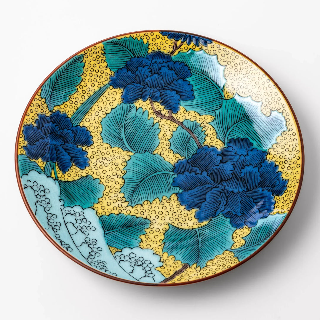 Japanese porcelain dessert plate with blue peony flowers green leaves and golden yellow background.