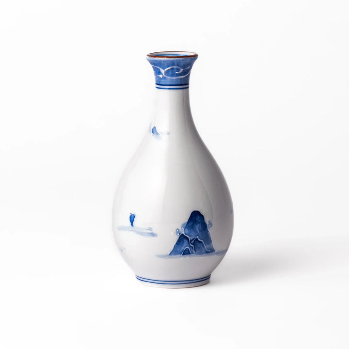 Porcelain sake flask with hand painted blue mountain and village scene red rim and elegant traditional shape.