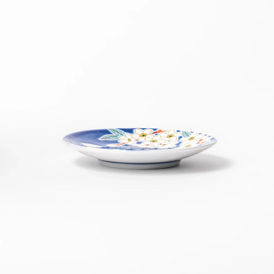 Blue Japanese ceramic sauce dish with white sakura blossom design for serving soy sauce or condiments.