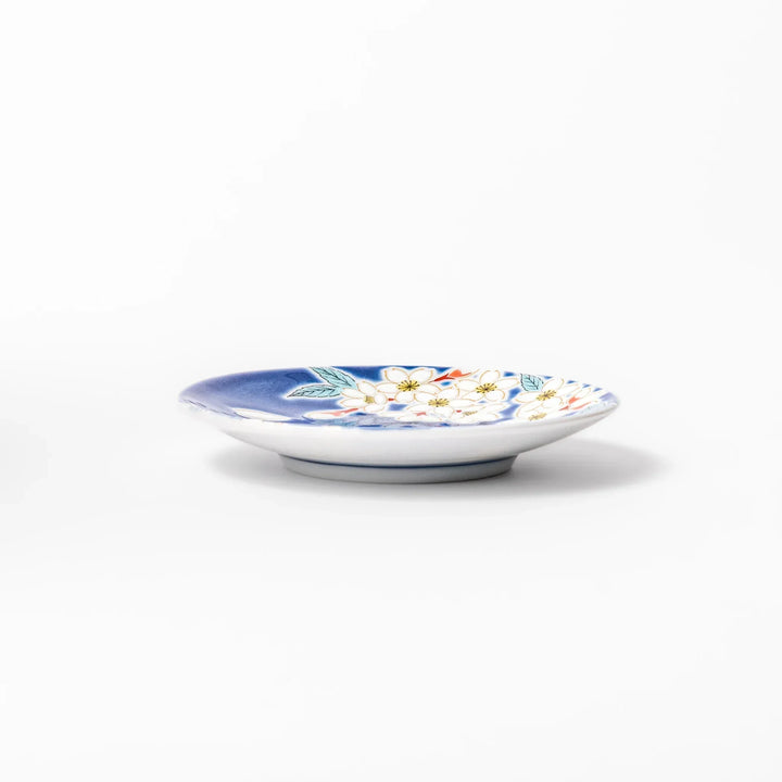 Blue Japanese ceramic sauce dish with white sakura blossom design for serving soy sauce or condiments.