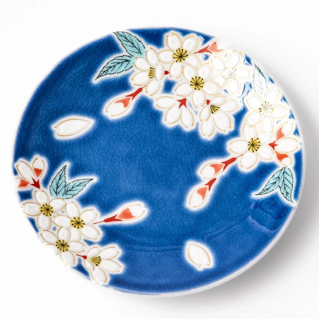 Blue Japanese ceramic sauce dish with white sakura blossom design for serving soy sauce or condiments.