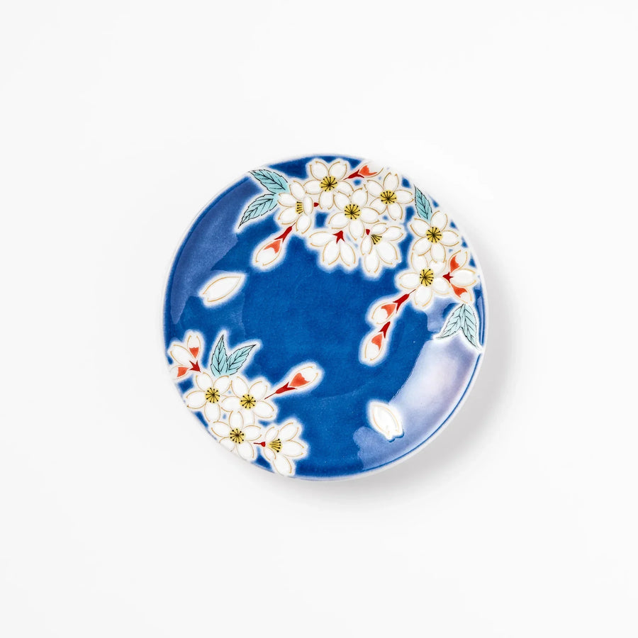 Blue Japanese ceramic sauce dish with white sakura blossom design for serving soy sauce or condiments.