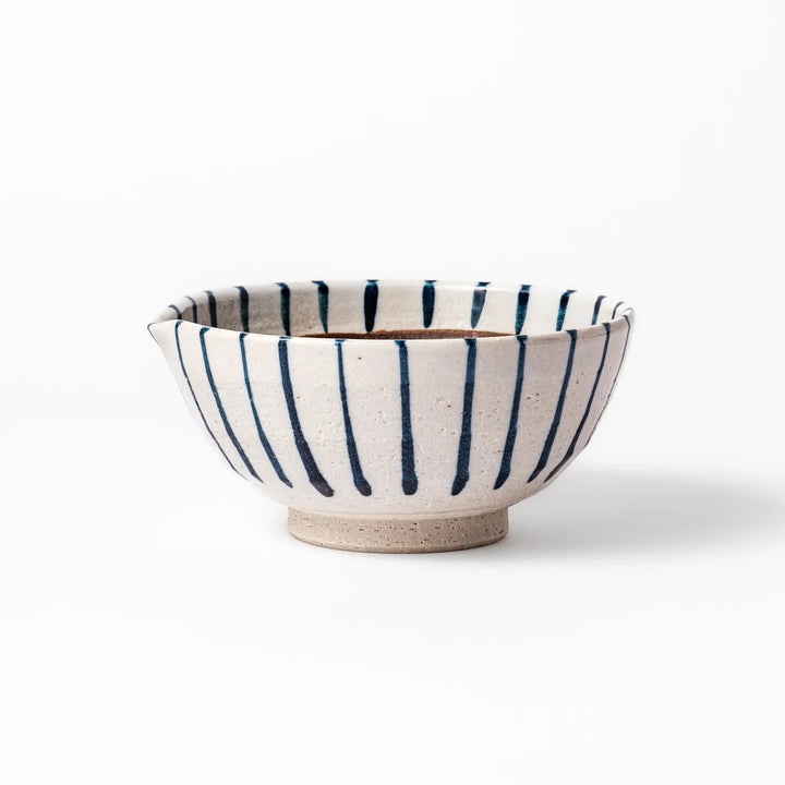White ceramic suribachi mortar with blue stripes and brown textured interior for grinding sesame seeds.