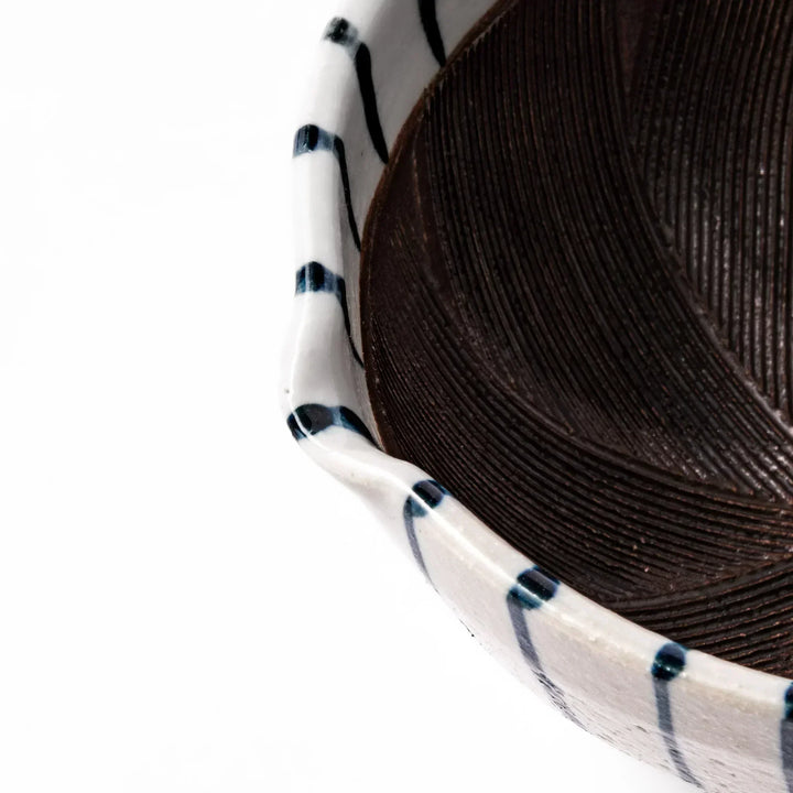 White ceramic suribachi mortar with blue stripes and brown textured interior for grinding sesame seeds.