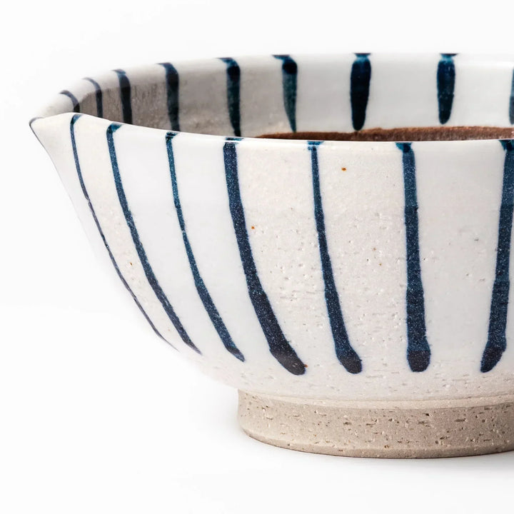 White ceramic suribachi mortar with blue stripes and brown textured interior for grinding sesame seeds.