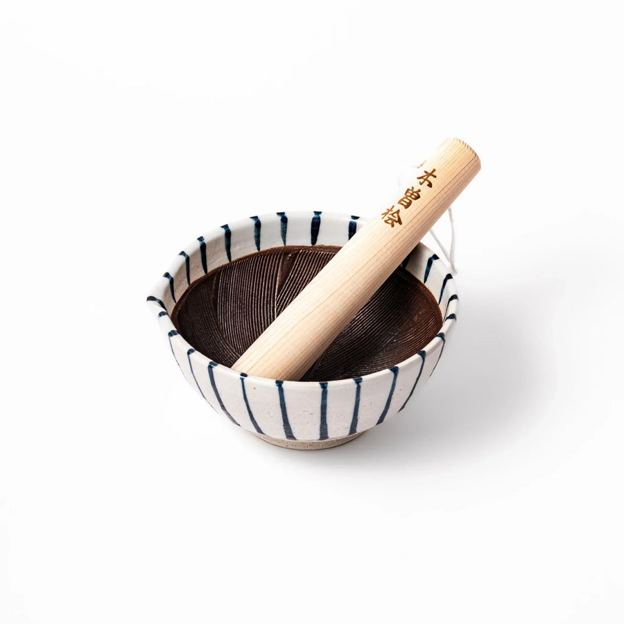 Blue-striped ceramic suribachi mortar with textured brown interior and wooden pestle, perfect for grinding sesame seeds and preparing Japanese sauces.