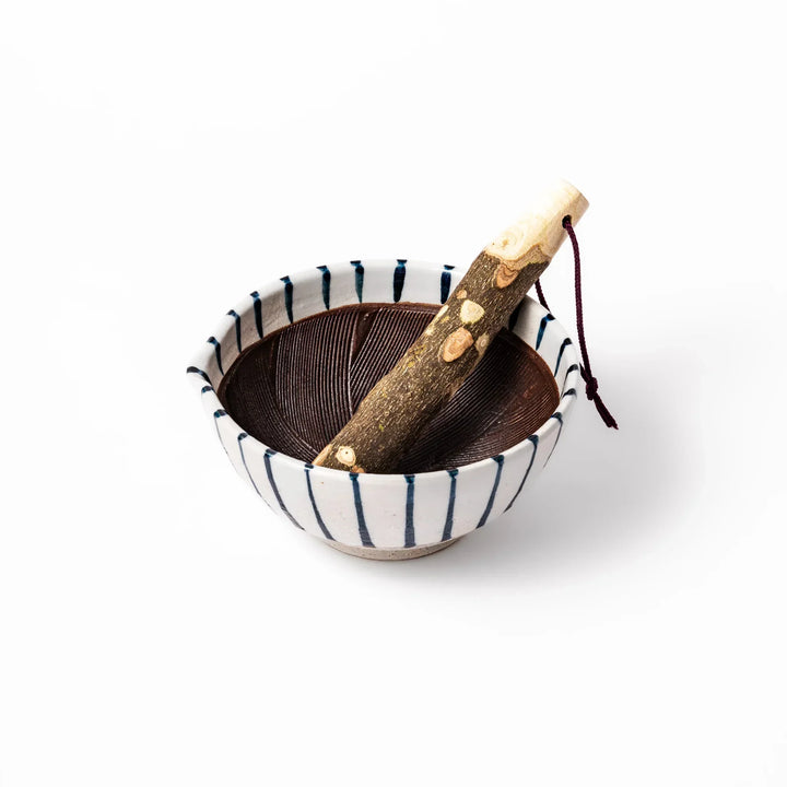 Blue striped Japanese ceramic suribachi mortar with brown grooved interior and wooden pestle for spices.