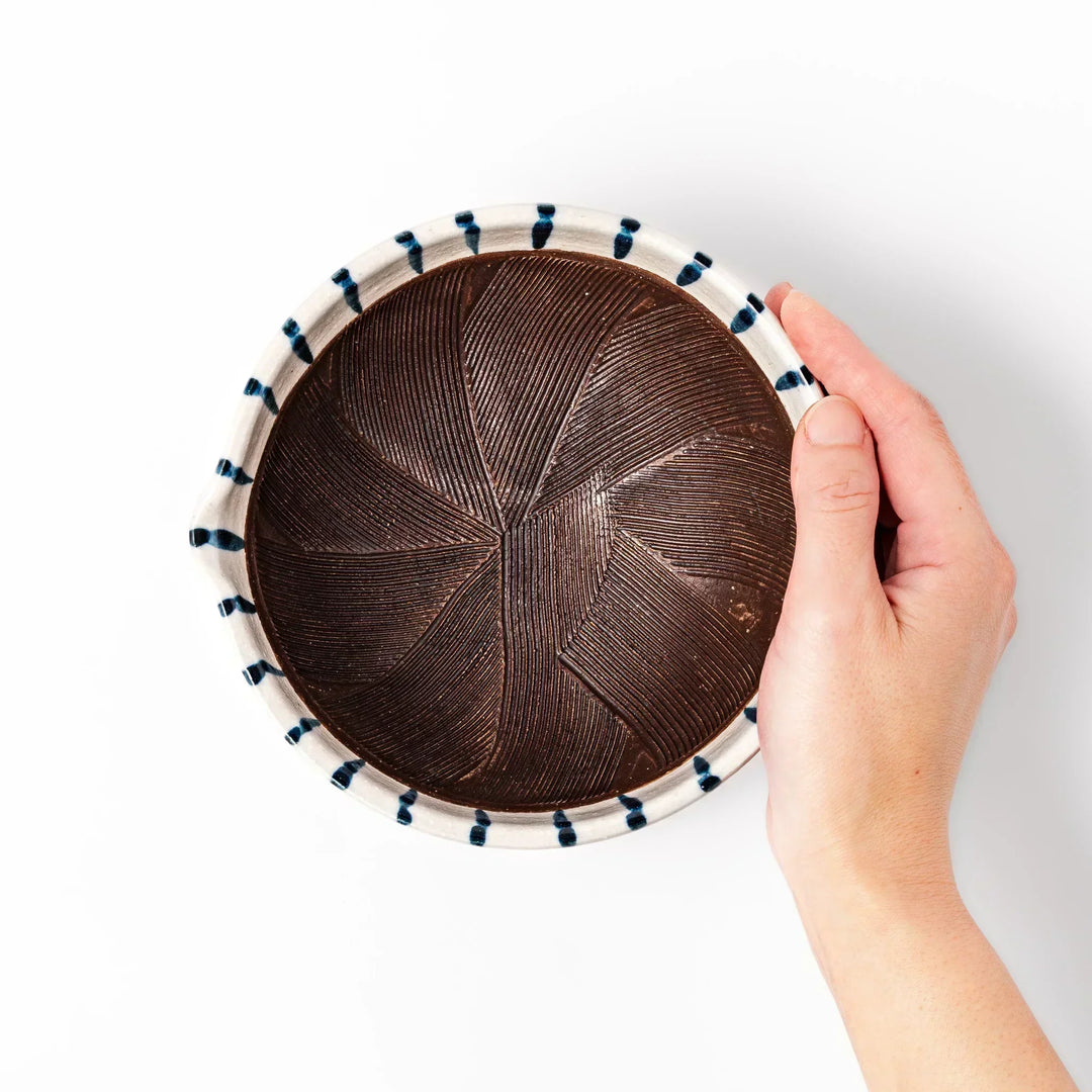 White ceramic suribachi mortar with blue stripes and brown textured interior for grinding sesame seeds.