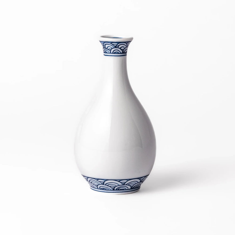 Porcelain sake flask with a smooth white body accented by traditional blue seigaiha wave patterns around the neck and base.