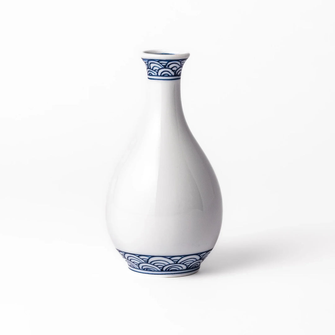 Porcelain sake flask with a smooth white body accented by traditional blue seigaiha wave patterns around the neck and base.