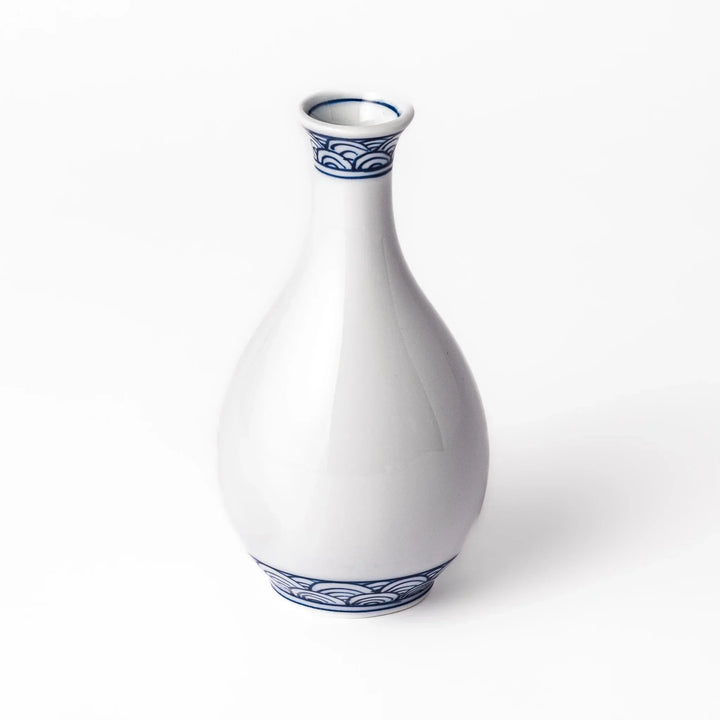 Porcelain sake flask with a smooth white body accented by traditional blue seigaiha wave patterns around the neck and base.