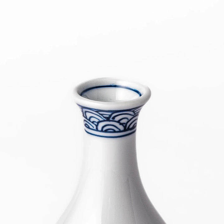 Porcelain sake flask with a smooth white body accented by traditional blue seigaiha wave patterns around the neck and base.