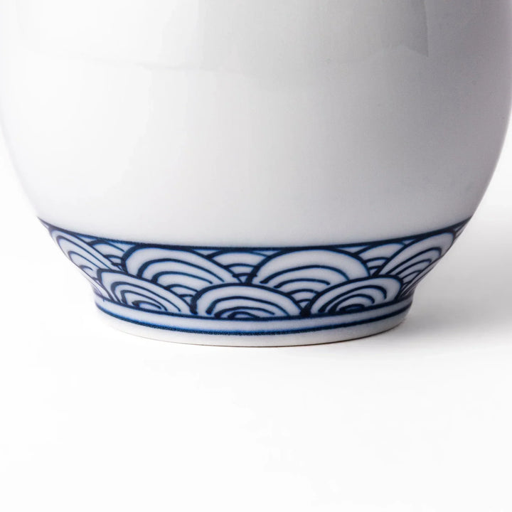 Porcelain sake flask with a smooth white body accented by traditional blue seigaiha wave patterns around the neck and base.