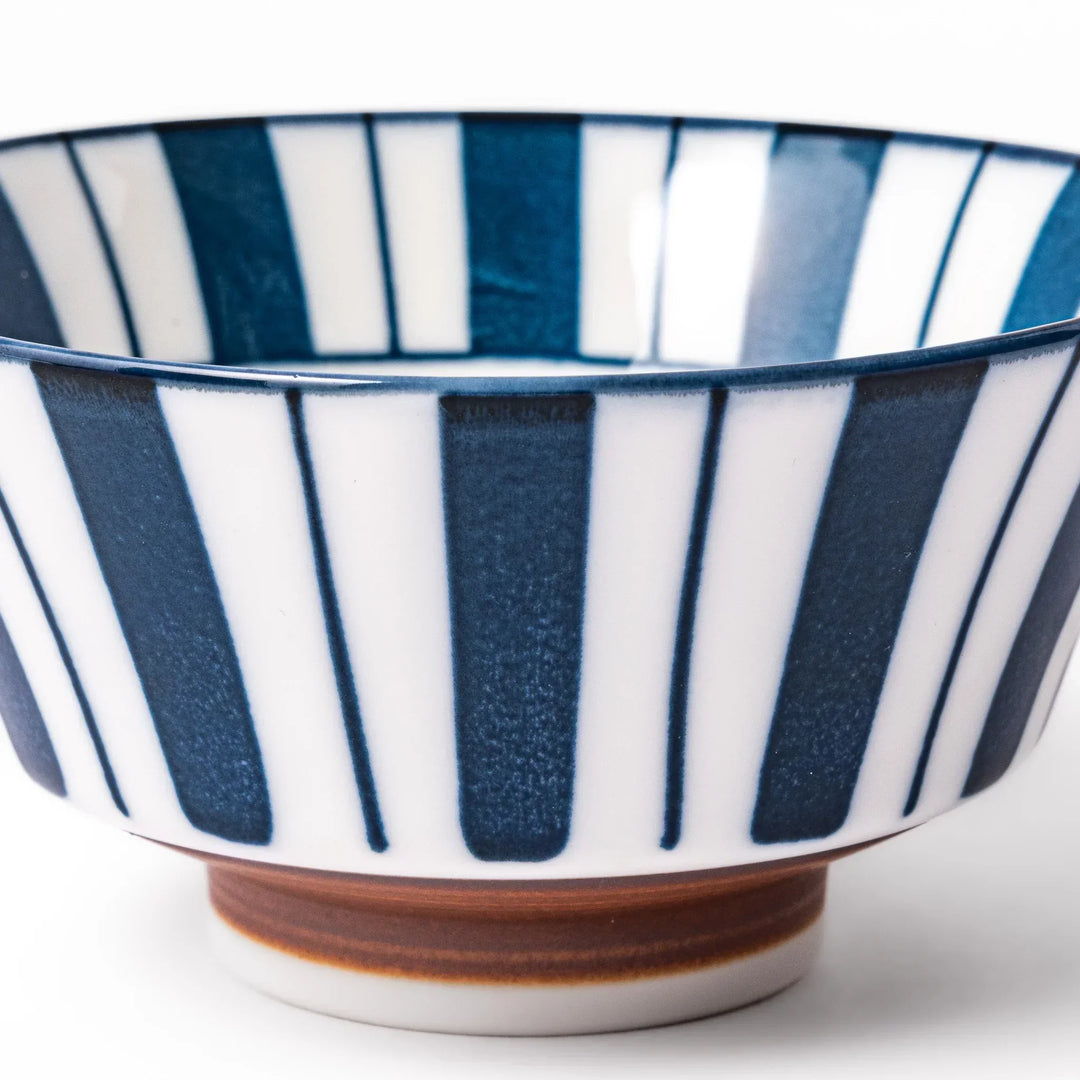 Japanese porcelain rice bowl with bold indigo and white stripes and terracotta base in modern classic style.
