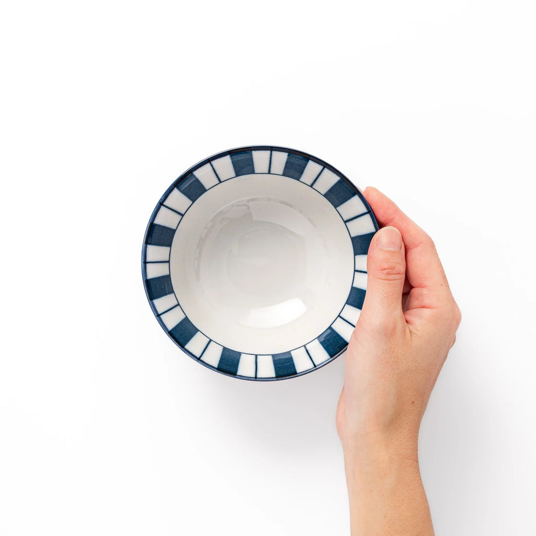 Japanese porcelain rice bowl with bold indigo and white stripes and terracotta base in modern classic style.