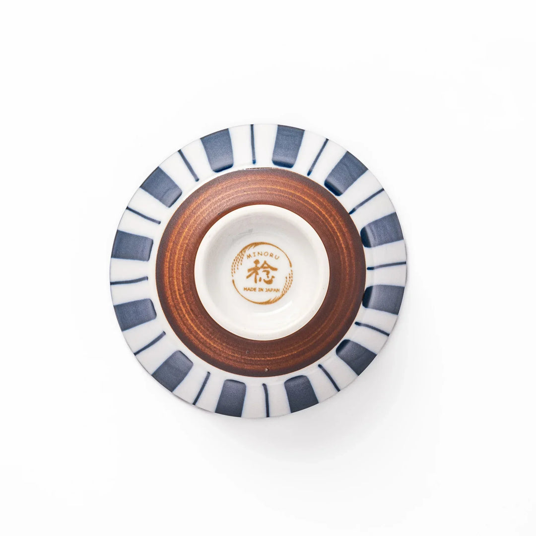 Japanese porcelain rice bowl with bold indigo and white stripes and terracotta base in modern classic style.