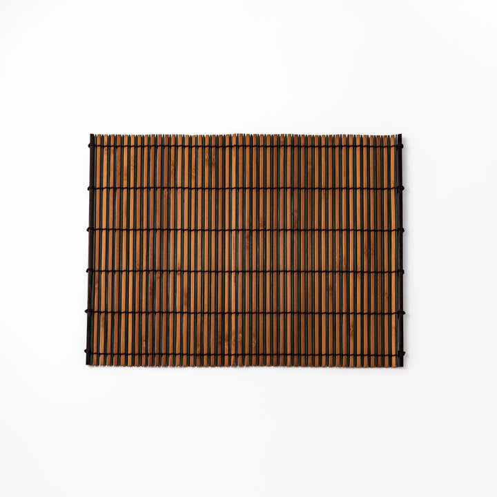 Brown bamboo table mat with dark and natural slats bound with black cord for warm Japanese table settings.