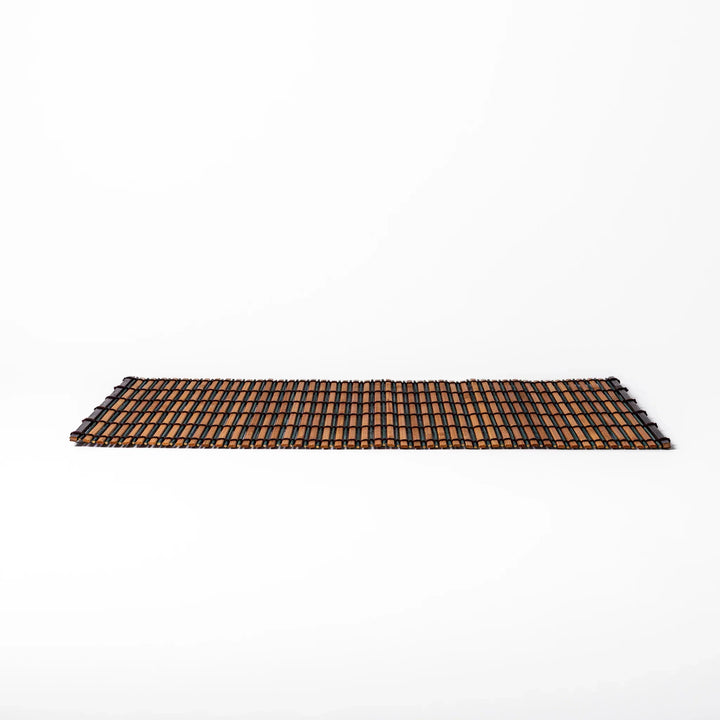 Brown bamboo table mat with dark and natural slats bound with black cord for warm Japanese table settings.