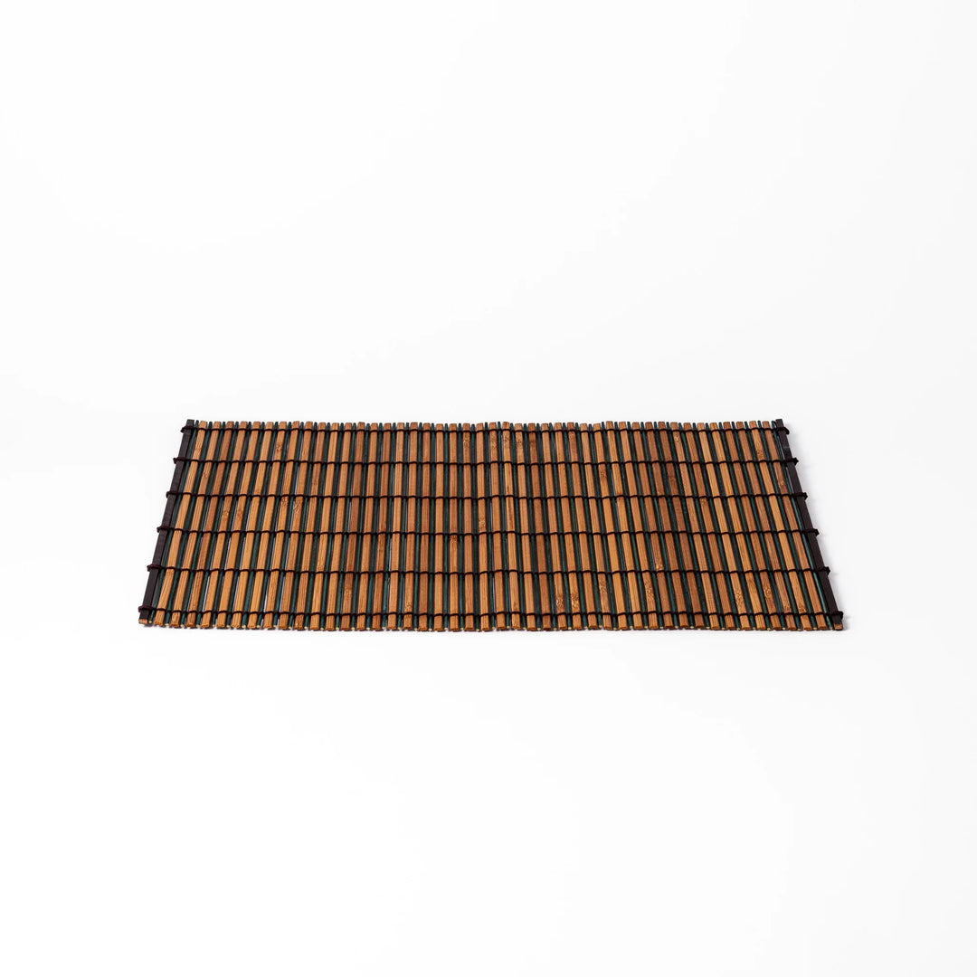 Brown bamboo table mat with dark and natural slats bound with black cord for warm Japanese table settings.