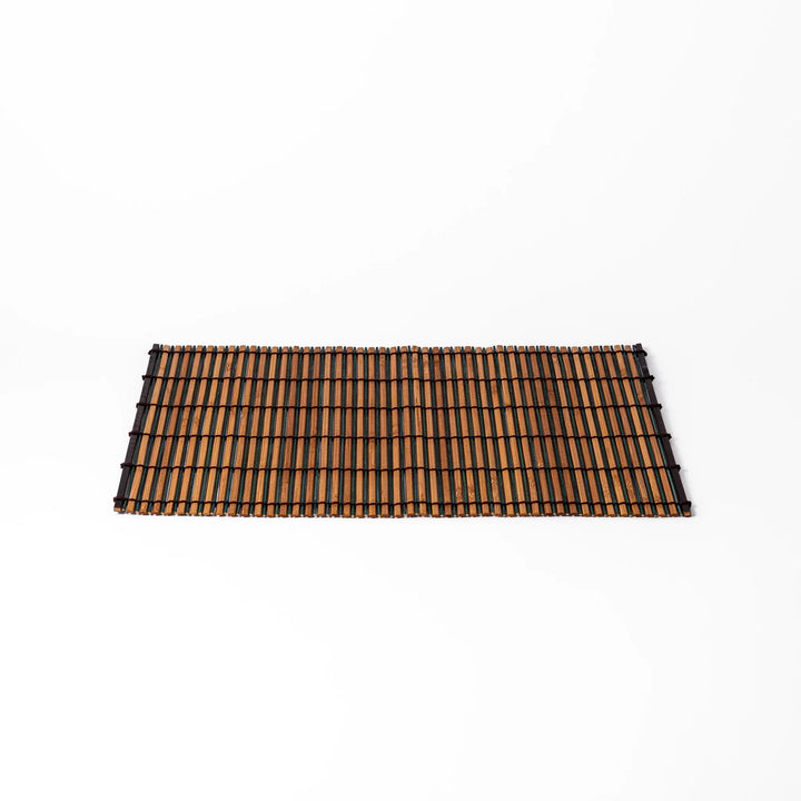 Brown bamboo table mat with dark and natural slats bound with black cord for warm Japanese table settings.