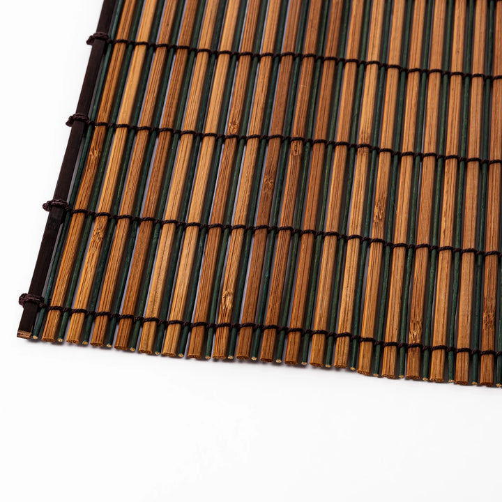 Brown bamboo table mat with dark and natural slats bound with black cord for warm Japanese table settings.