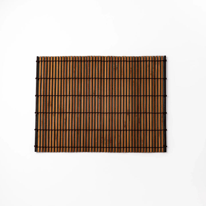 Brown bamboo table mat with dark and natural slats bound with black cord for warm Japanese table settings.
