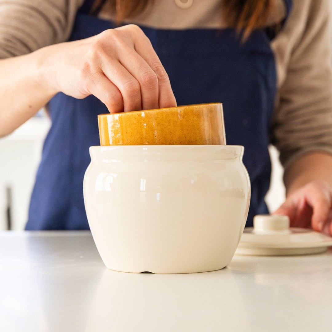 Nami from Just One Cookbook placing inner weight into ceramic asazuke pickle jar