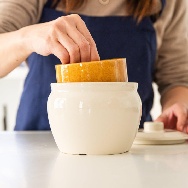 Nami from Just One Cookbook placing inner weight into ceramic asazuke pickle jar