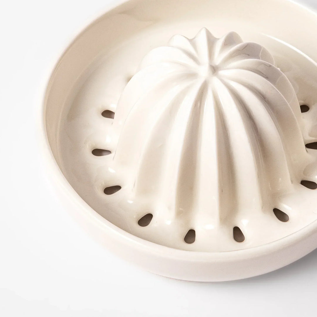 White Japanese ceramic citrus juicer with ridged reamer and strainer for squeezing lemons limes and citrus.