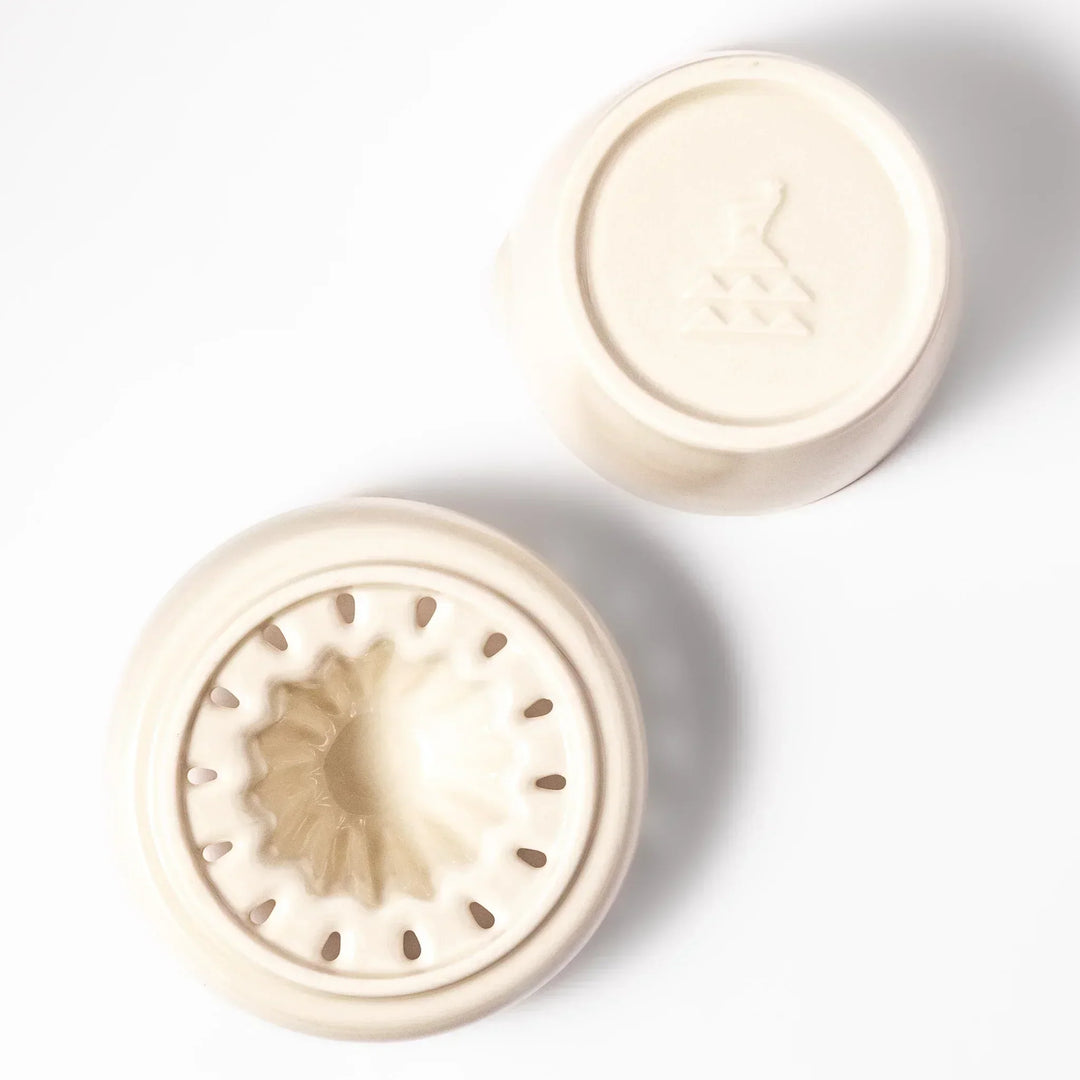 White Japanese ceramic citrus juicer with ridged reamer and strainer for squeezing lemons limes and citrus.