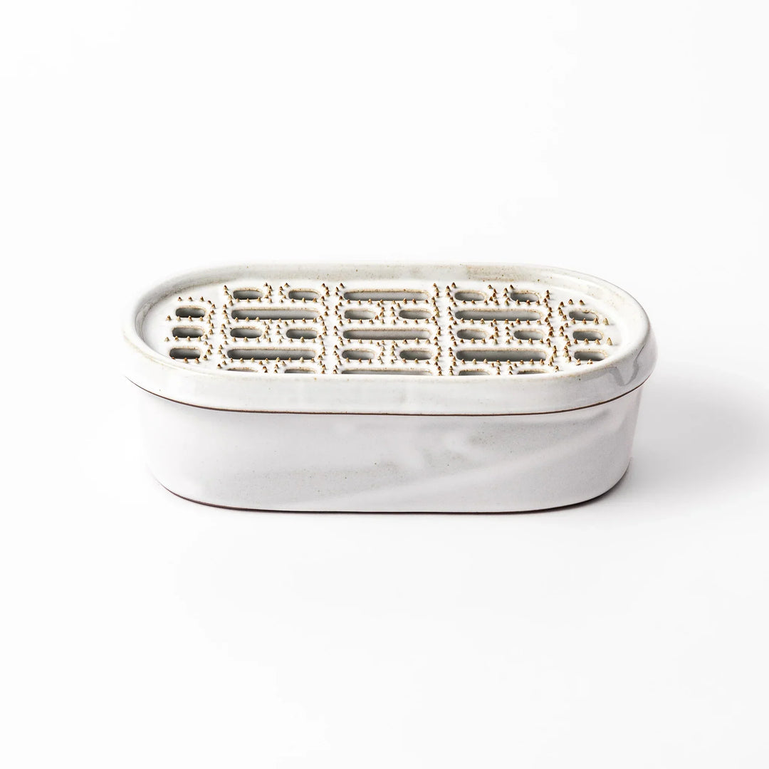 White Japanese ceramic daikon oroshi grater with built in dish and wide holes for grating daikon or ginger.