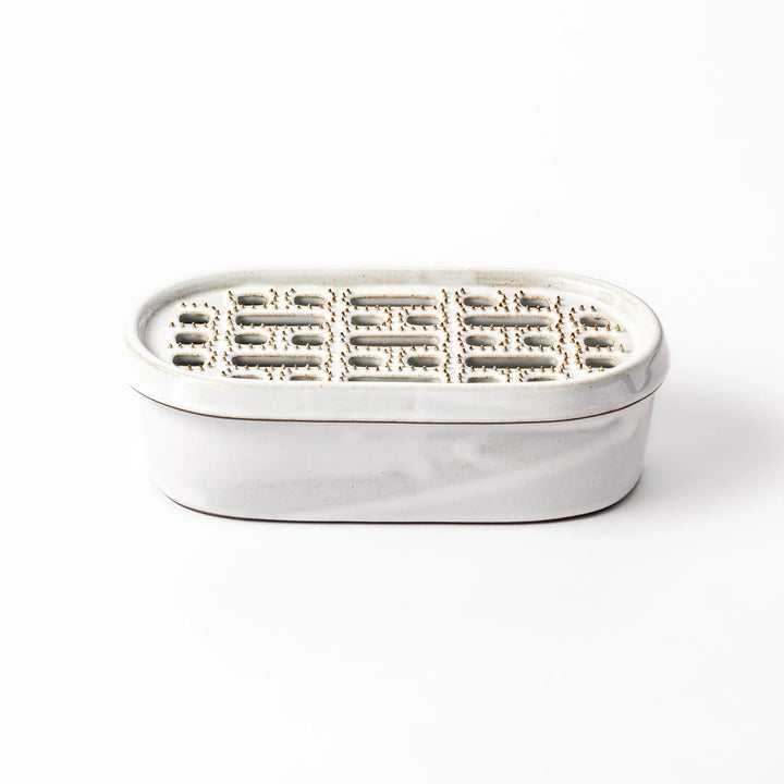 White Japanese ceramic daikon oroshi grater with built in dish and wide holes for grating daikon or ginger.