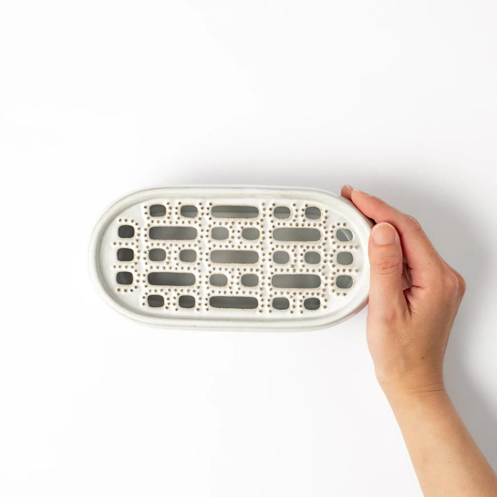 White Japanese ceramic daikon oroshi grater with built in dish and wide holes for grating daikon or ginger.