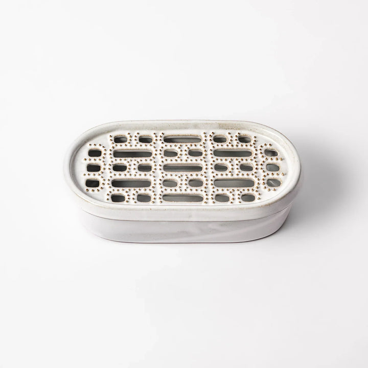 White Japanese ceramic daikon oroshi grater with built in dish and wide holes for grating daikon or ginger.