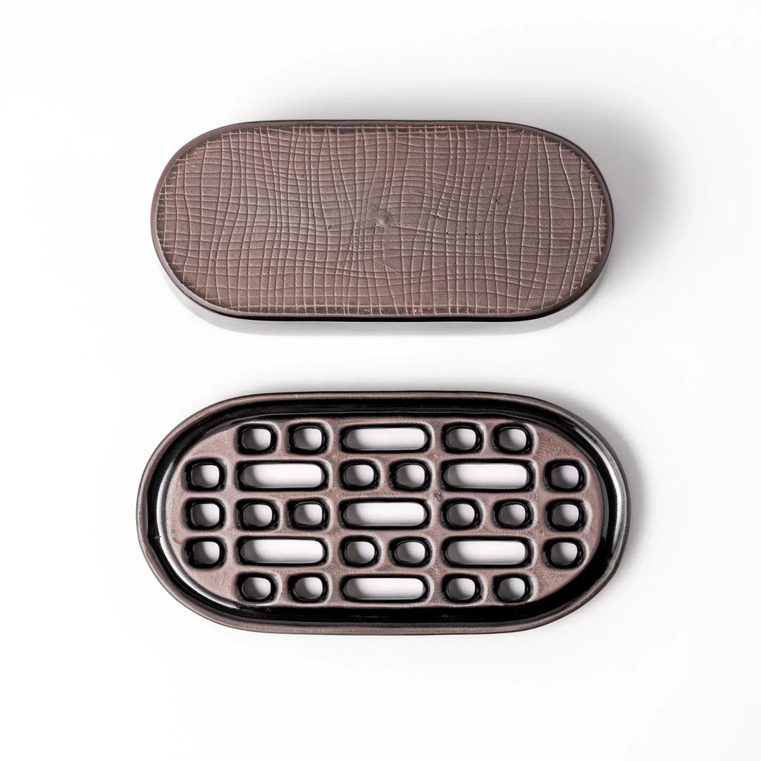 Black Japanese ceramic daikon oroshi grater with built in dish and wide holes for smooth grating cleanup.