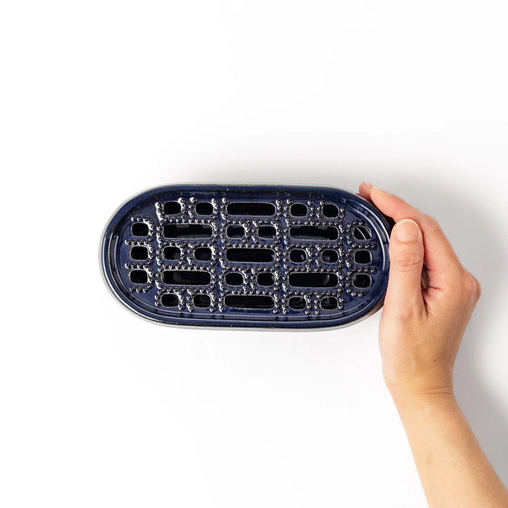 Deep blue Japanese ceramic daikon oroshi grater with built in dish and raised texture for easy grating.