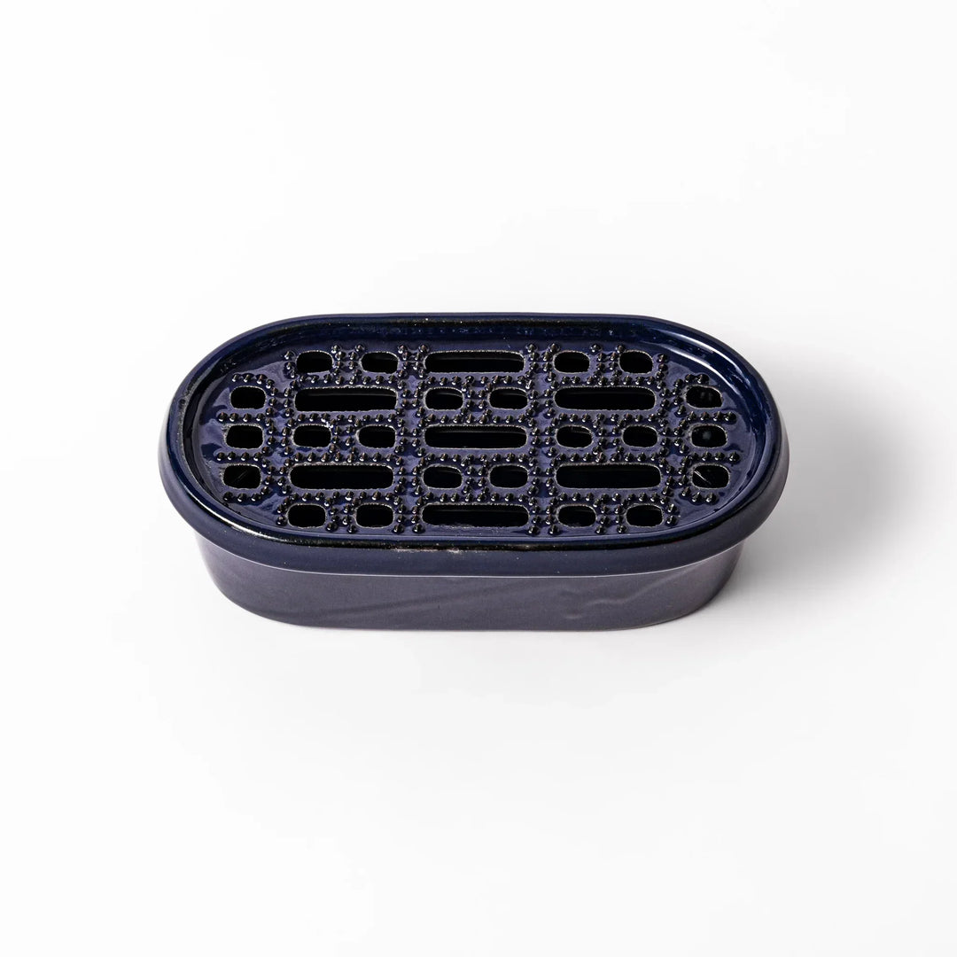 Deep blue Japanese ceramic daikon oroshi grater with built in dish and raised texture for easy grating.