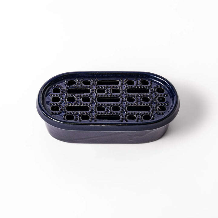 Deep blue Japanese ceramic daikon oroshi grater with built in dish and raised texture for easy grating.