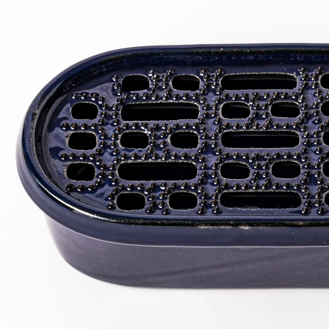 Deep blue Japanese ceramic daikon oroshi grater with built in dish and raised texture for easy grating.